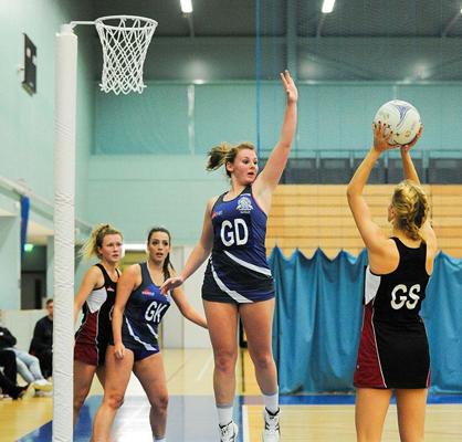 women playing netball in a gym