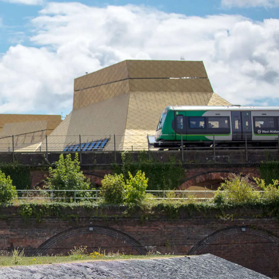 A train passing on the rail bridge beside the Hive library