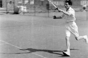 Woman playing tennis in white kit
