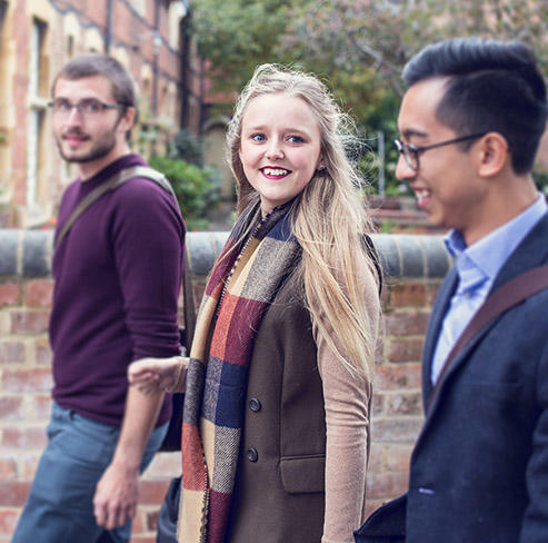 Students walking past red brick buildings