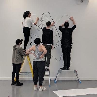 students at a white wall creating artistic shapes