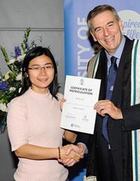 Linh Hong Vu receiving an award and shaking hands with Vice Chancellor David Green