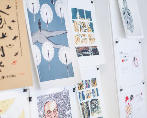 Student illustration work pinned to wall