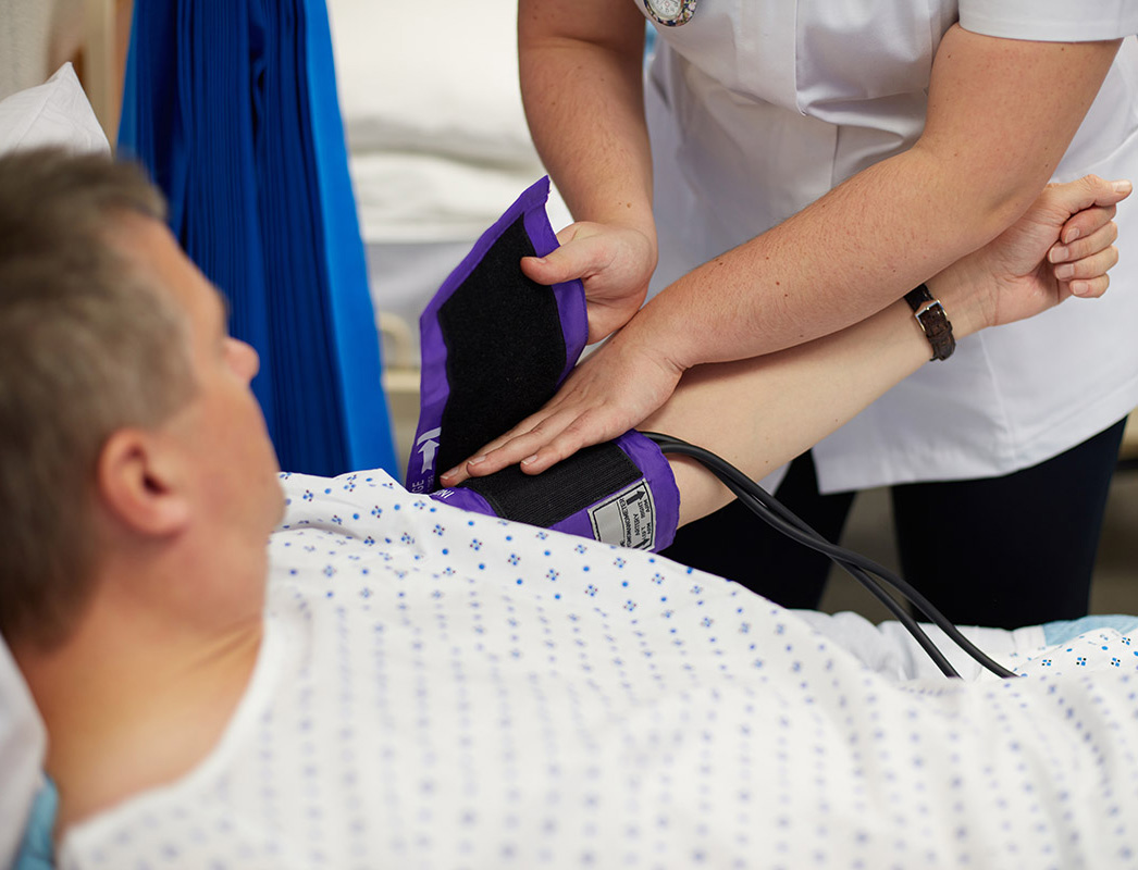 A patient is having their blood pressure taken