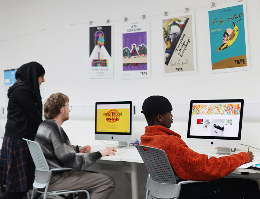 Three students looking at webpage designs on computers