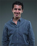 man with black hair and a blue checked shirt