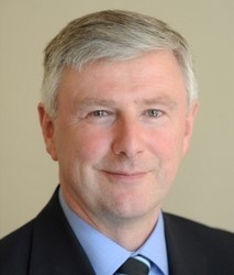 portrait photo of a grey-haired man wearing a tie