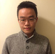 portrait photo of a young man with glasses and a beige top