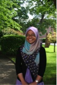 young woman wearing a pink headscarf and glasses