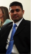 young man wearing a blue tie and dark jacket
