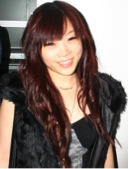 asian woman with reddish hair and wearing a dark top