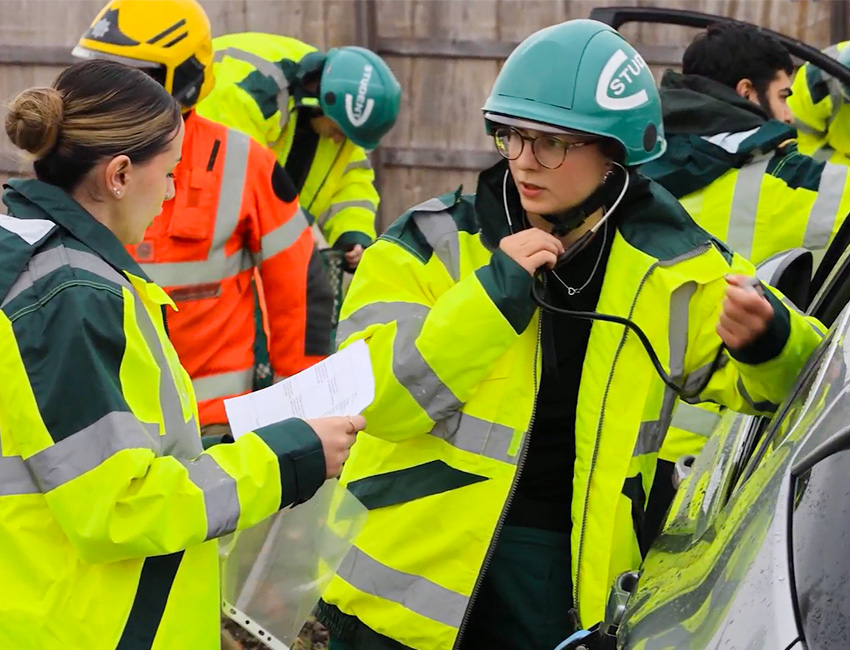 Students in high-vis working at a simulated car crash