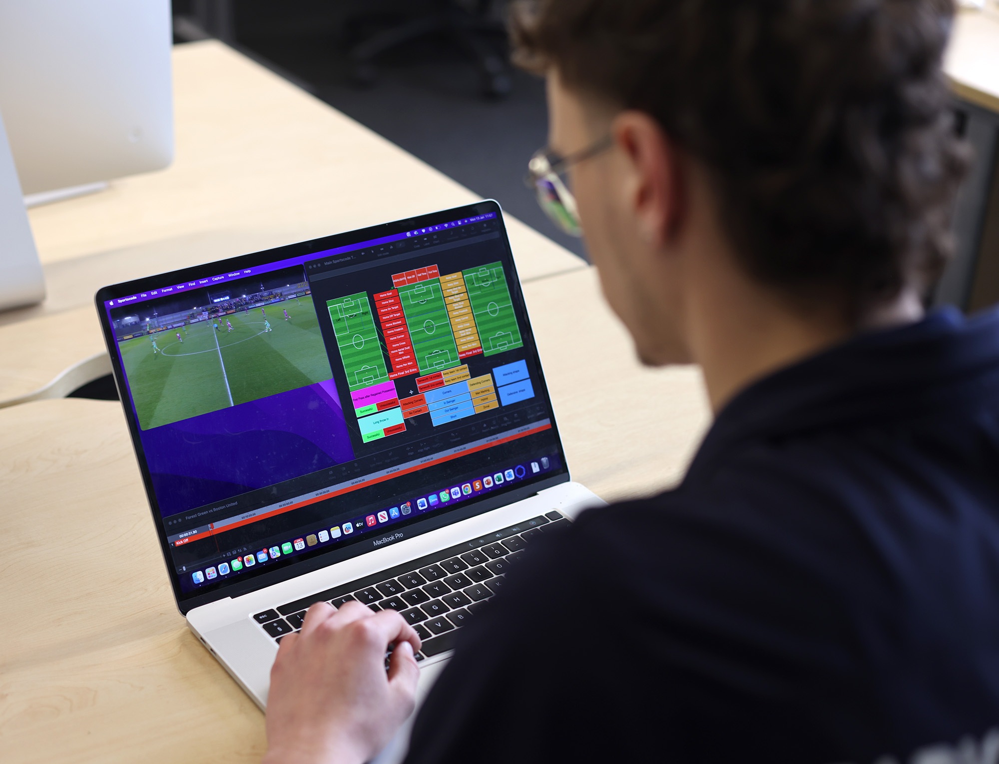 Male student analysing a football game on his laptop