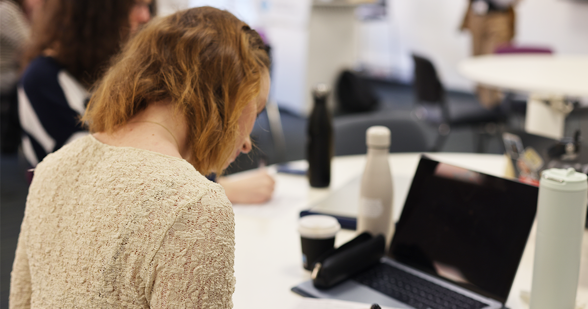 Student looking down at their notes in a classroom