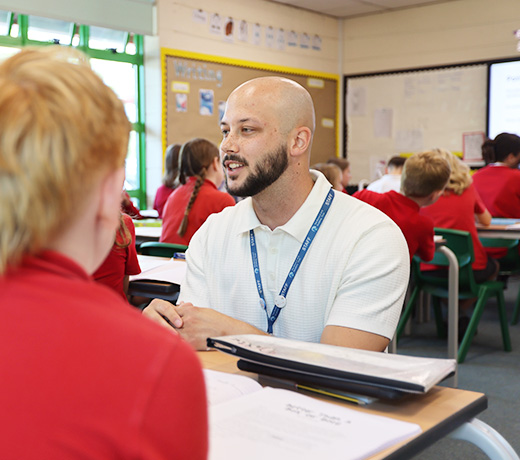 A student teacher speaking with school children in the primary school classroom.