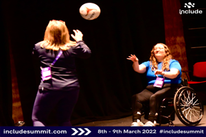 Woman in Wheelchair throwing netball to woman standing at Include Summit