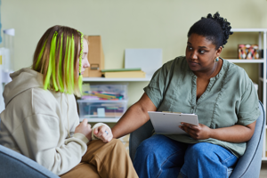 Therapist sitting with a women in an room offering support