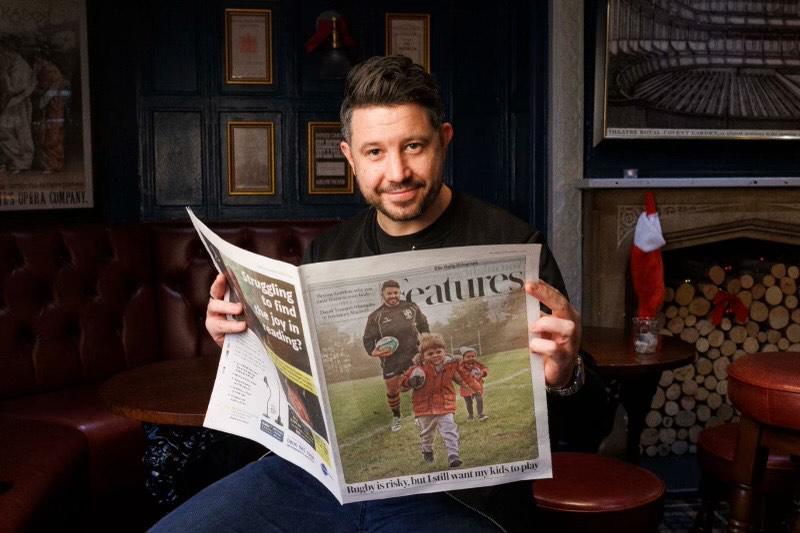 Gareth Davies holding a newspaper