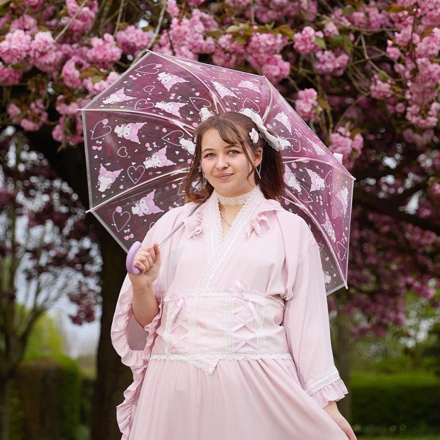 Georgina Briggs in pink Japanese clothing with pink cherry blossoms behind her
