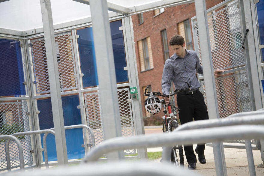 Man pushing bike into storage