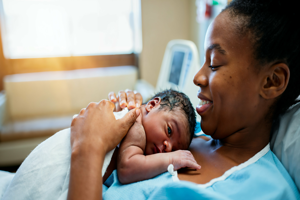 Mother in a hospital room holding her new born baby.