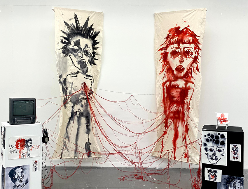 Student work - Two people painted on separatae sheets of paper, attached with various pieces of string