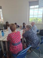 A group of conference delegates sitting around circular tables