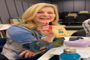 Attendee at Transformative Tales Event during Storytelling Activity hold a picture frame.