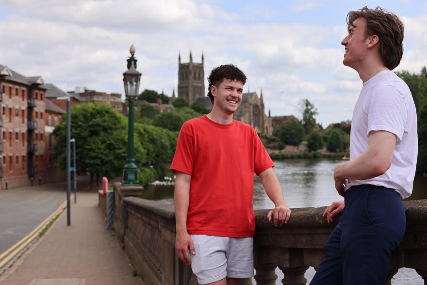 Two students having a catch up on the bridge with the cathedral in the background
