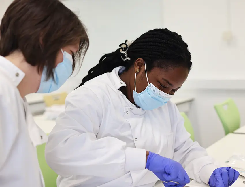 A student working in a lab with their lecturer