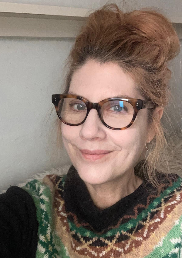 A selfie of Angie Butler wearing a patterned jumper and glasses