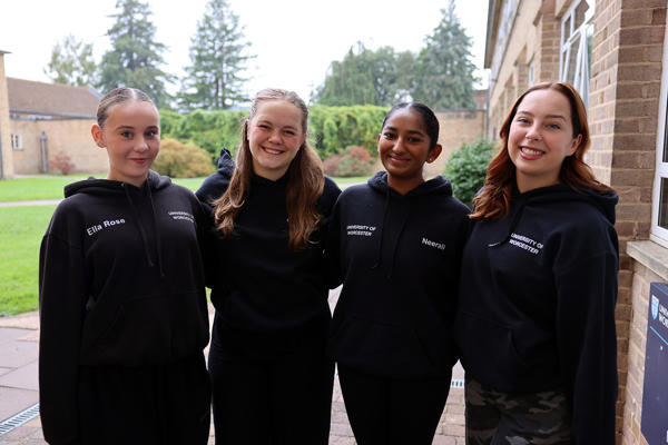 Four Bridges of Light Dancers pose in their black hoodies together looking at the camera