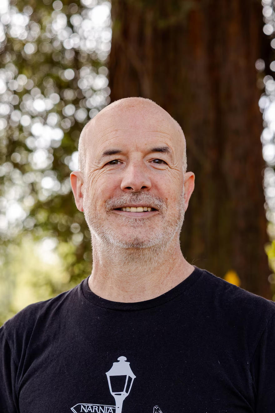 UW Dan Johnson smiles in a portrait shot wearing a black tshirt