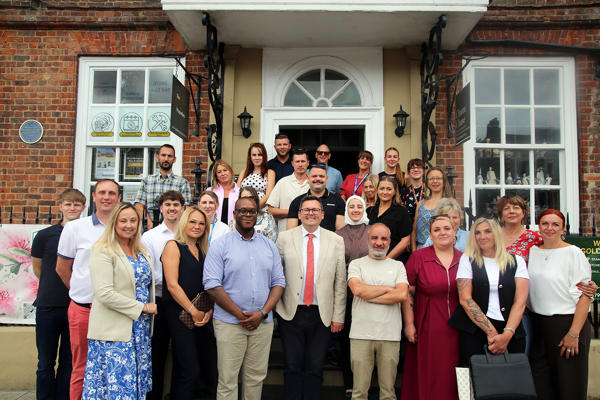 Around 30 attendees of the launch stand outside on the steps