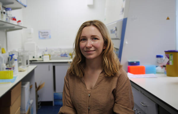 Gemma Allcott smiles at the camera in a science lab
