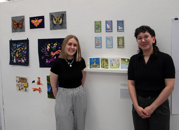 Hannah and Marisa pose next to Hannah's award winning artwork