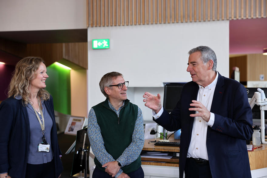 Three people talk in the hive library