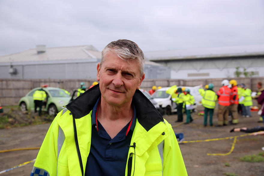 UW Phil Edwards smiles while wearing a high vis jacket