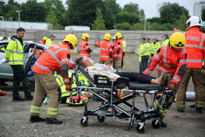A firefighter pushes a hospital trolley with an injured patient on