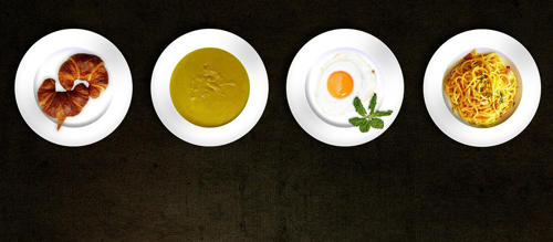 Several plates full of food are in a row. These include croissants, soup and egg on toast