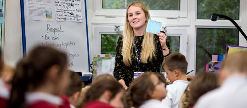 A female teacher training student in a classroom working on placement as part of her degree to get into teaching.