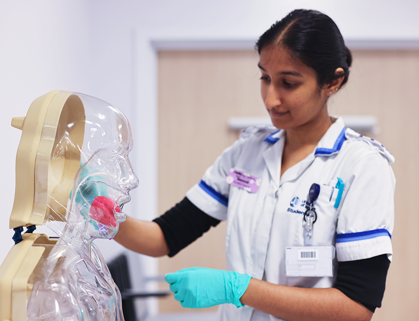 Student nurse practicing with a model of a person