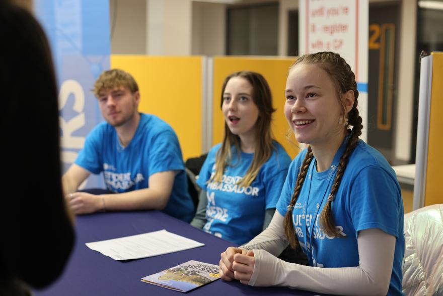 Student ambassador sat at a table welcoming someone