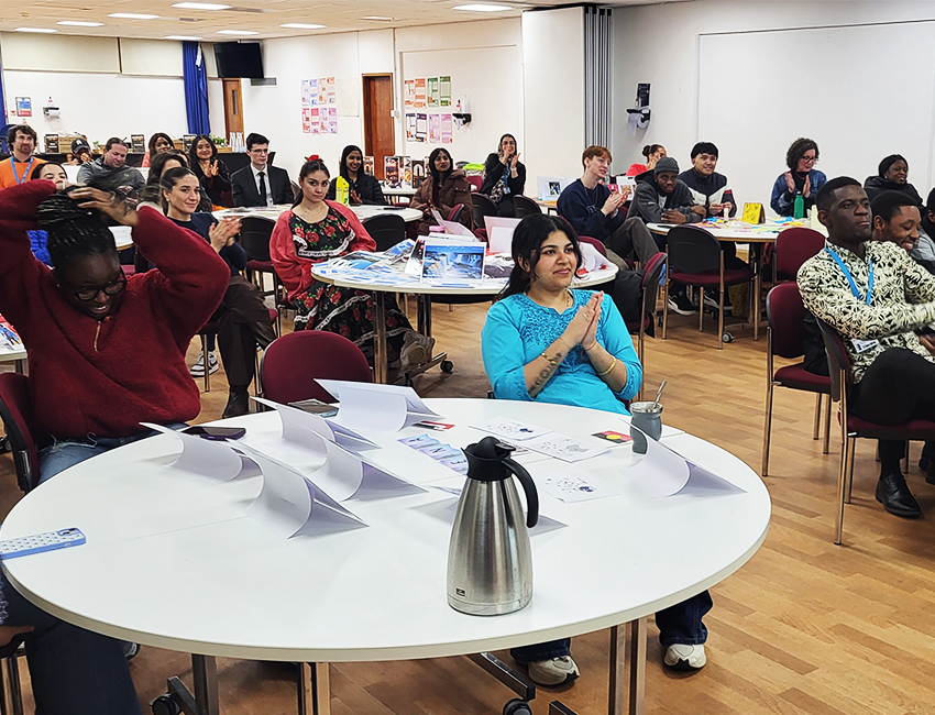 Students of different ethnicities sitting together enjoying a presentation