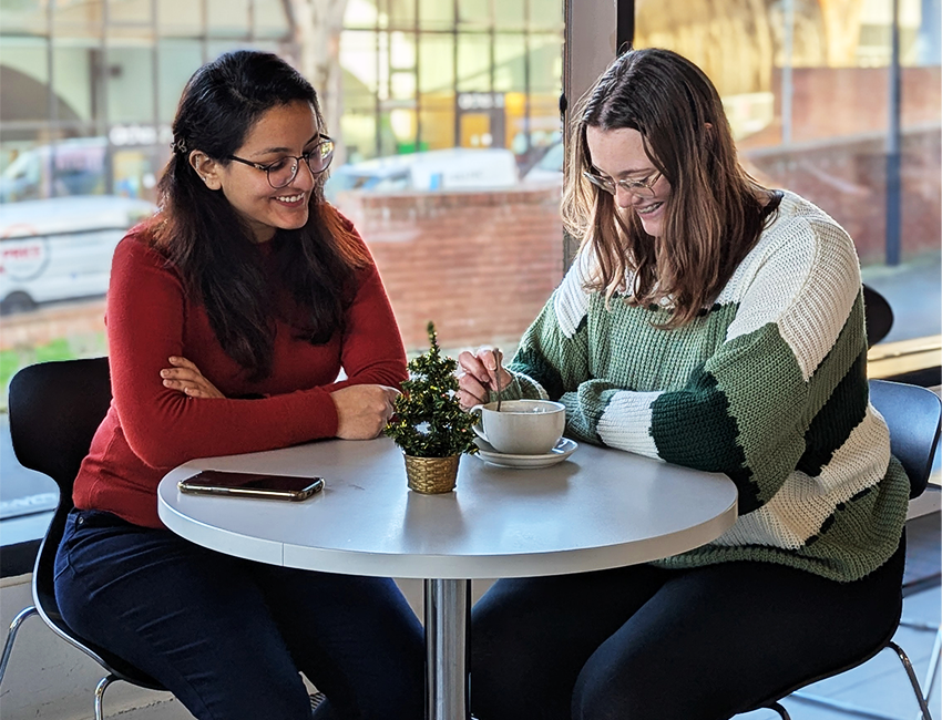Two students catching up in library cafe