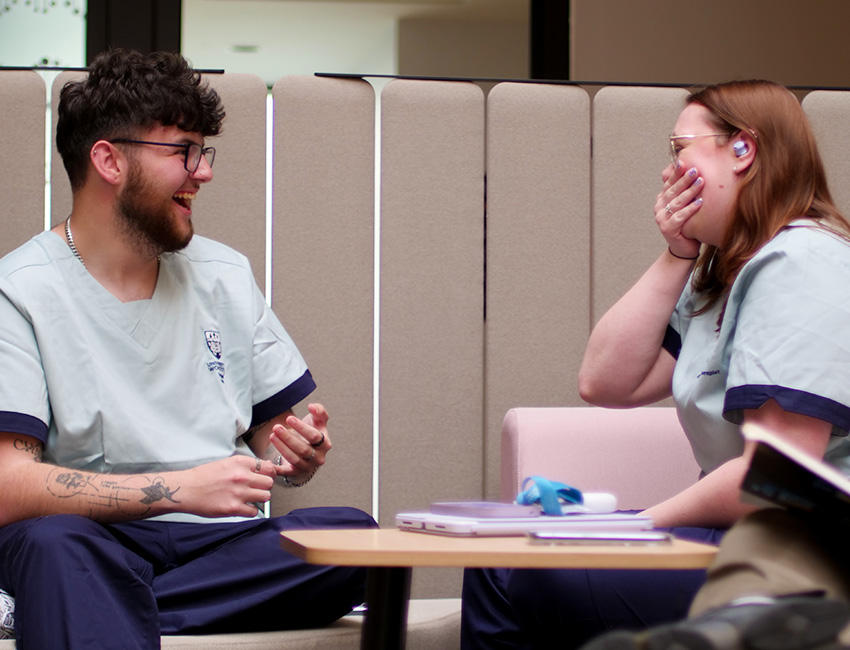 Two students sat together laughing