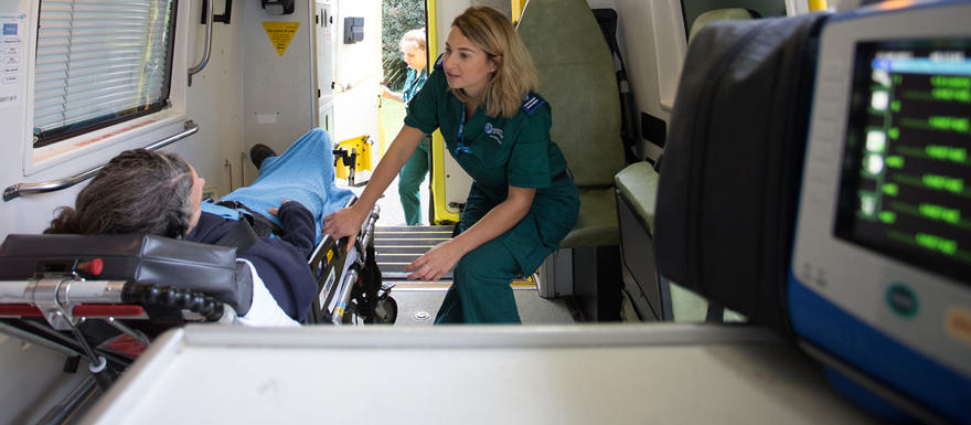 A paramedic student with a medical manikin in a training ambulance.
