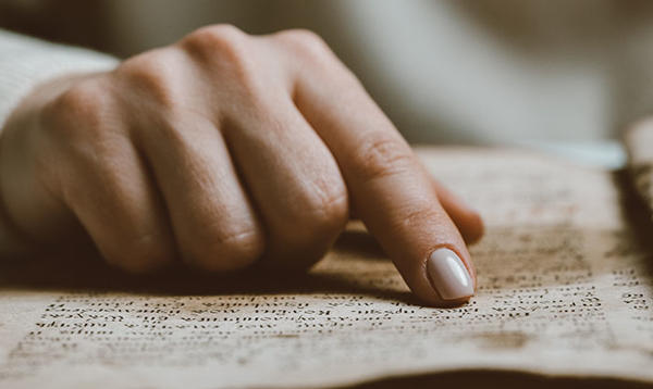 a hand looking over an old text