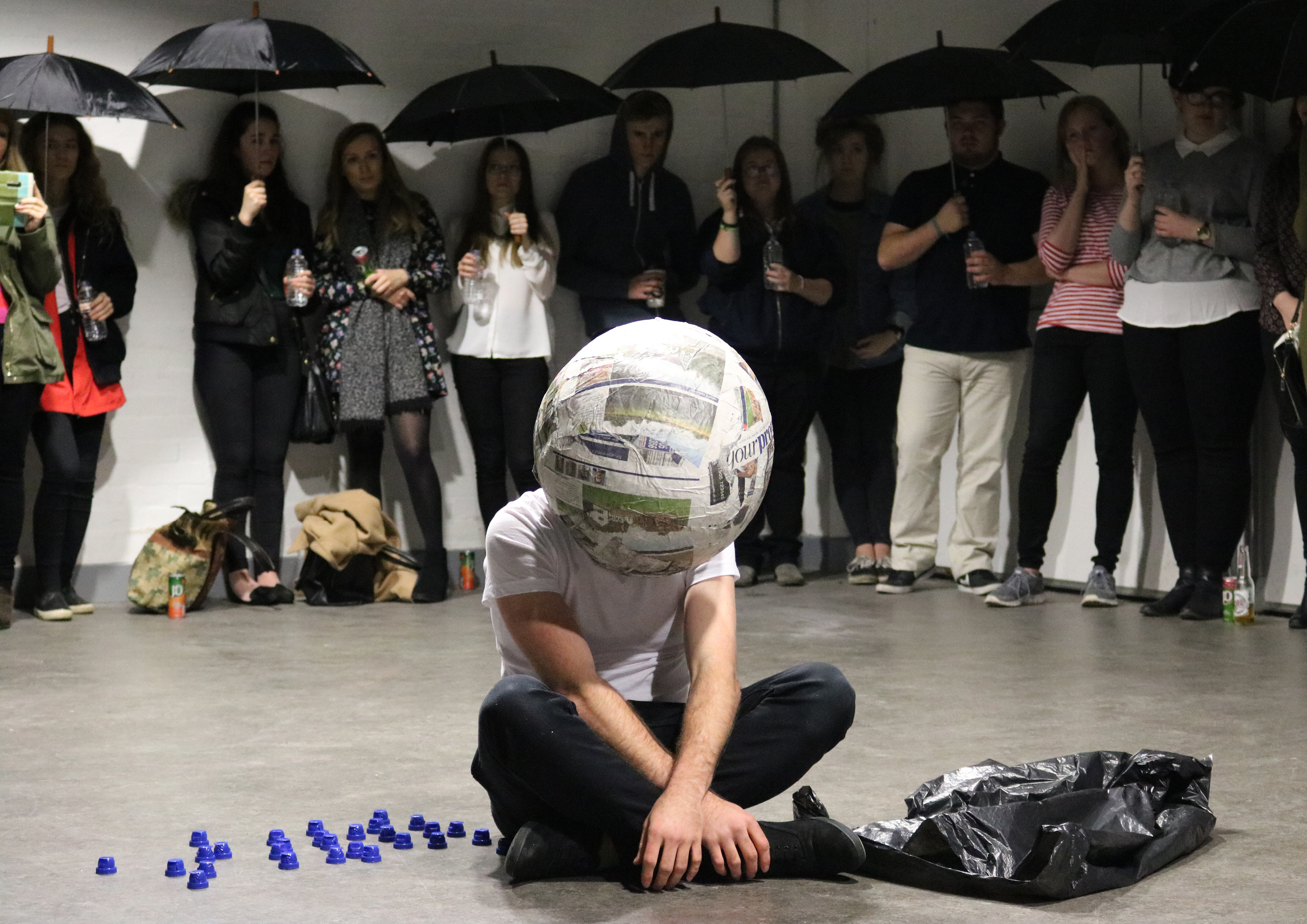 Fine Art degree student work, student sat on the floor with art surrounding