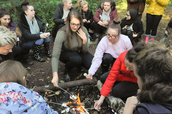 Group of Early Childhood in Society students at an open fire